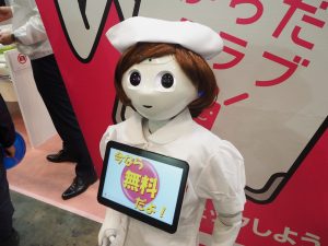 生活革命のシステムで強化したペッパーがドラッグストアショーのブースの前で、お客様を集めました。 ナース帽にかつらで可愛くなりました